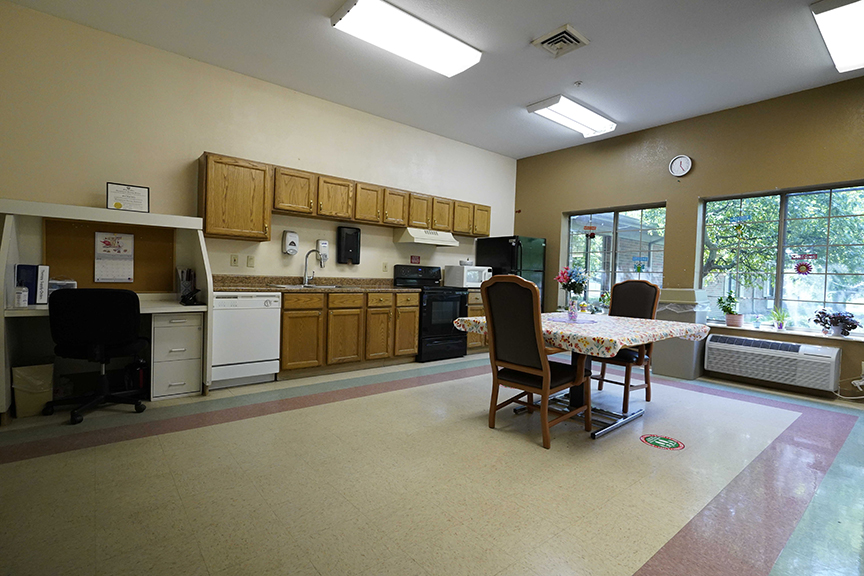 Kitchenette, table set and office station in resident lounge- Arbors at Sylvania